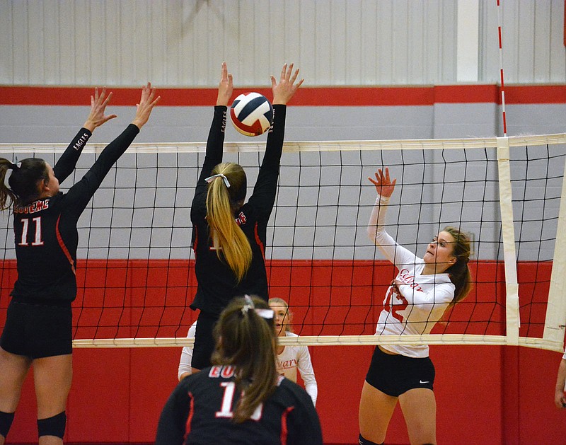 Abigail Fisher of Calvary Lutheran spikes the ball through the arms of a Eugene player during a Class 1 district match last month at Calvary.