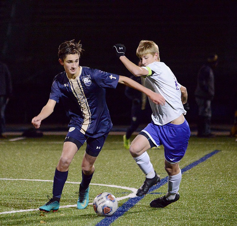 Sam Conley of Helias kicks the ball past Josh Gerdiman of Camdenton during Thursday night's Class 3 District 9 Tournament title game at the Crusader Athletic Complex.