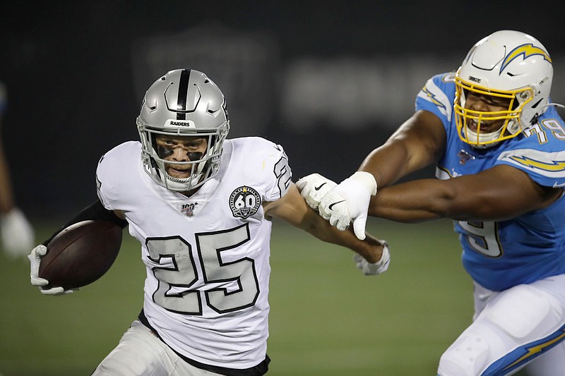 Raiders free safety Erik Harris runs past Chargers offensive tackle Trey Pipkins to return an interception for a touchdown during the first half of Thursday night's game in Oakland, Calif.