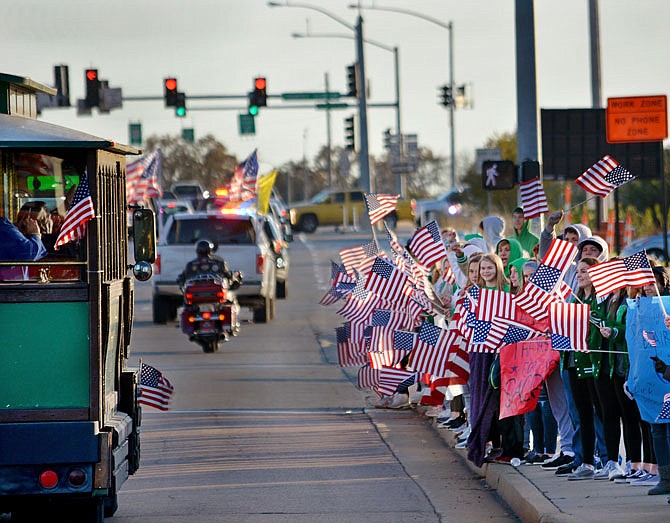 Student athletes with Blair Oaks High School wave their flags Thursday as veterans and their families travel by trolley along Amazonas Drive during the "Wave 'Em If You Have 'Em" motorcade to the Operation Bugle Boy Veterans Appreciation Night at the Knights of Columbus in St. Martins.
