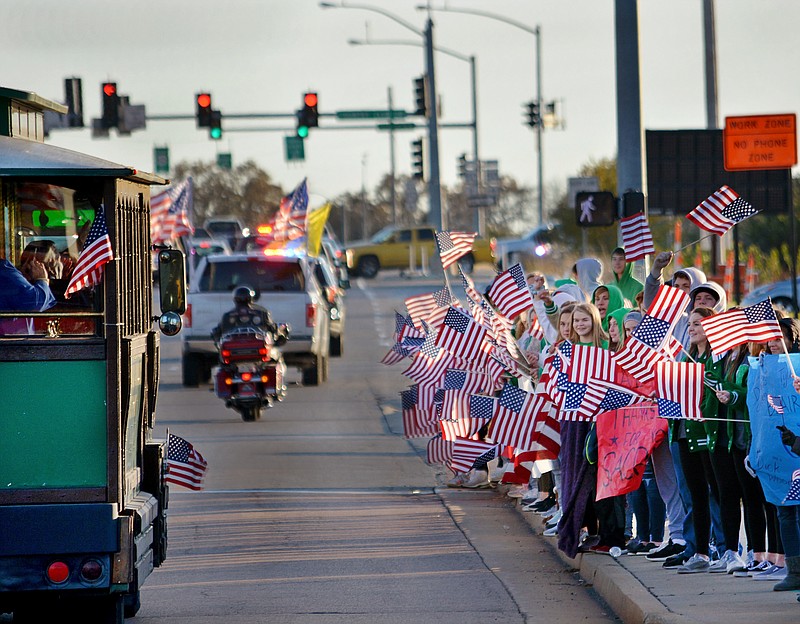 Sally Ince/ News Tribune  
Student athletes with Blair Oaks High School wave their flags as veterans and their families travel by trolly along Amazonas Drive Thursday November 7, 2019 during the Operation Bugle Boy’s Wave ‘Em If You Have ‘Em in a motorcade.