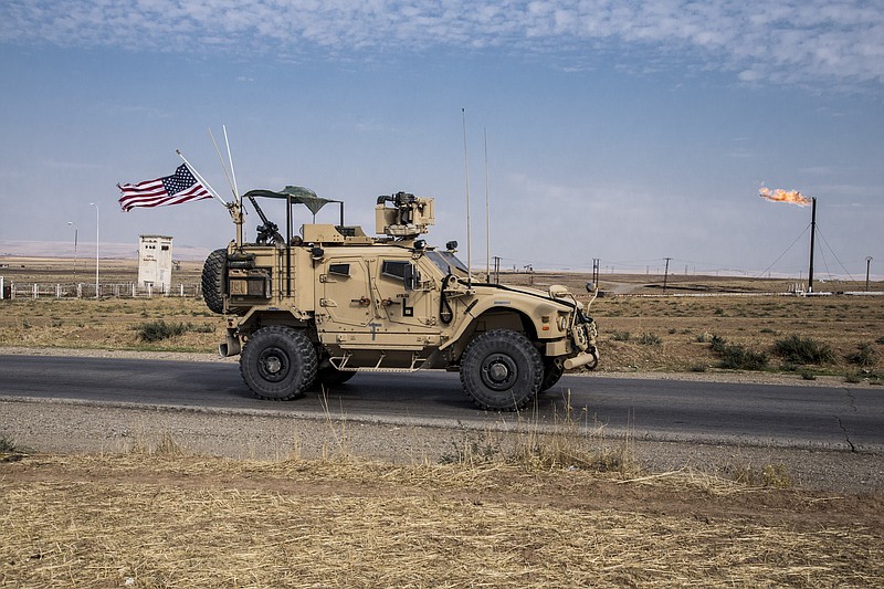 FILE - In this Monday, Oct. 28, 2019 file photo, U.S. forces patrol Syrian oil fields, in eastern Syria.President Donald Trump's decision to dispatch new U.S. forces to eastern Syria to secure oil fields is being criticized by some experts as ill-defined and ambiguous. But the residents of the area, one of the country's most remote and richest regions, hope the U.S. focus on eastern Syria would bring an economic boon and eliminate what remains of the Islamic State group. (AP Photo/Baderkhan Ahmad, File)