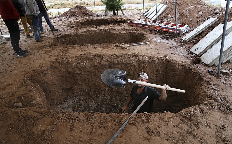 Men dig graves for Rhonita Miller, 30, and four of her young children Krystal and Howard, and twins Titus and Tiana, who were murdered by drug cartel gunmen, before their burial at a cemetery in LeBaron, Chihuahua state, Mexico, Friday, Nov. 8, 2019. A total of three women and six of their children, from the extended LeBaron family, were gunned down in a cartel ambush while traveling along Mexico's Chihuahua and Sonora state border on Monday. (AP Photo/Marco Ugarte)