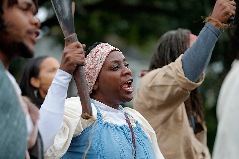 People participate in a performance artwork reenacting the largest slave rebellion in U.S. history in LaPlace, La., Friday, Nov. 8, 2019. The reenactment was conceived by Dread Scott, an artist who often tackles issues of racial oppression and injustice. Scott says that those who took part in the 1811 rebellion were "heroic" and that the rebellion is something that people should know about and be inspired by. (AP Photo/Gerald Herbert)