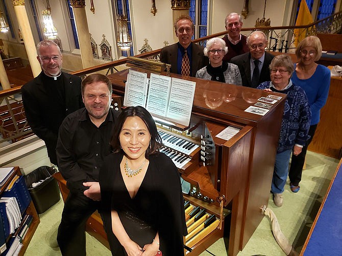 The Rev. Jeremy Secrist, visiting organist Horst Buchholz, visiting vocal soloist MeeAe Cecilia Nam and members of the local American Guild of Organists chapter stand next to the organ console in the choir loft of St. Peter Catholic Church in Jefferson City, following an Oct. 20 public concert of music for organ and voice.