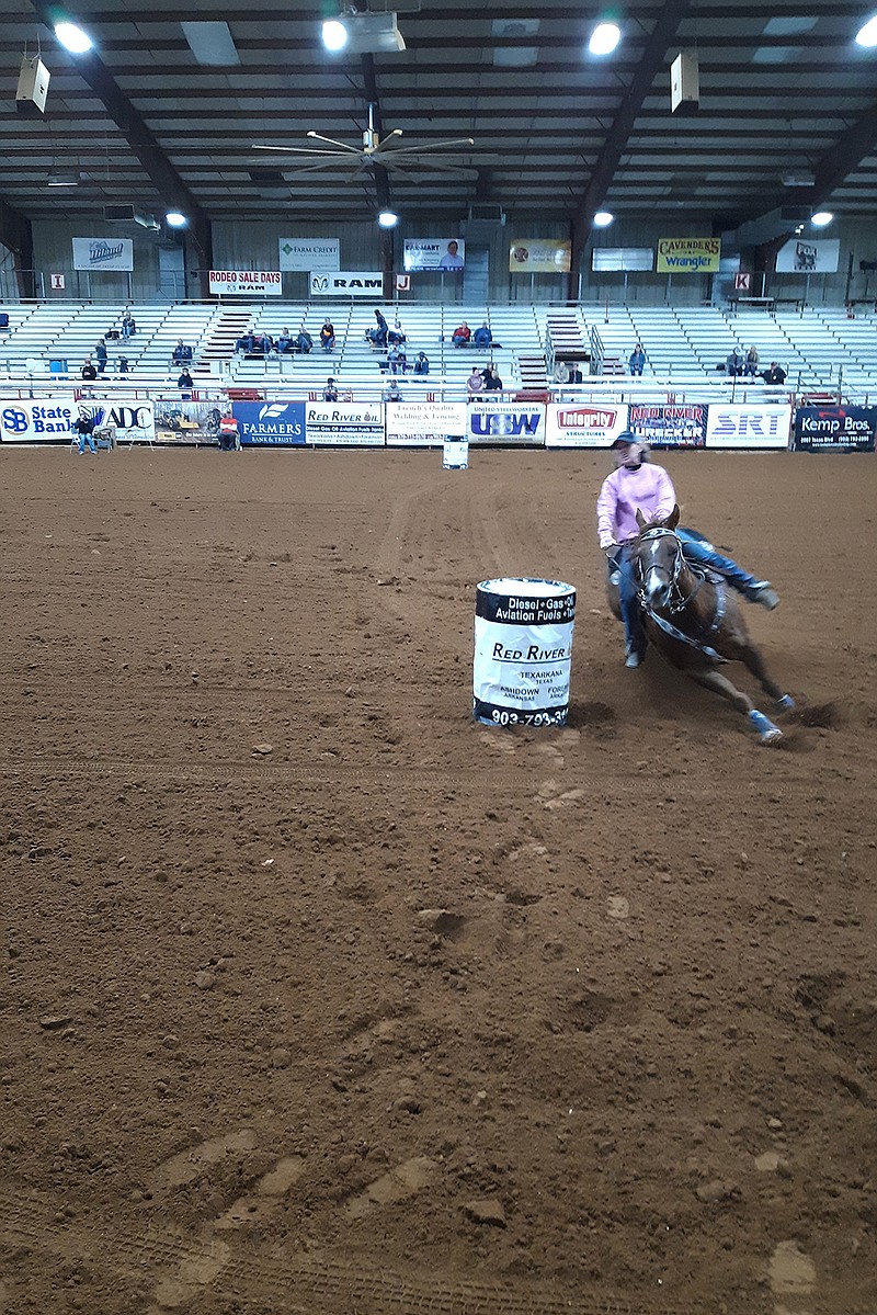 A barrel racer charges around three barrels placed in a triangle-shaped pattern for time. Many of these racers come from families who have been competing and raising horses for generations. 