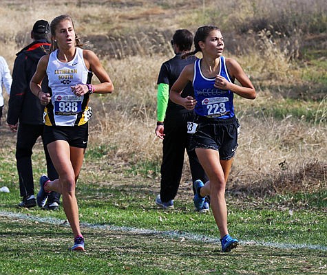 Capital City's Yumia Robben (right) checks out her surroundings as she runs in front of Lutheran South's Macy Schelp during Saturday's Class 3 state cross country championships at Gans Creek Cross Country Course in Columbia.