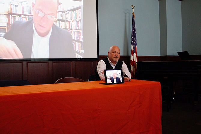Mark Boulton, chair of the Westminster College history department, accommodates for technology issues by holding a microphone to a device for Kurt Kemper's lecture. Westminster hosted a panel Friday to remind young students the impact of the Cold War on American life.