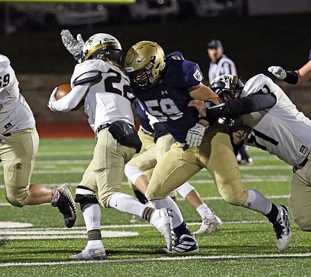 Helias' Jacob Watson gets set to tackle Lebanon running back Kale Keagy during Friday night's Class 4 District 5 semifinal at Ray Hentges Stadium.