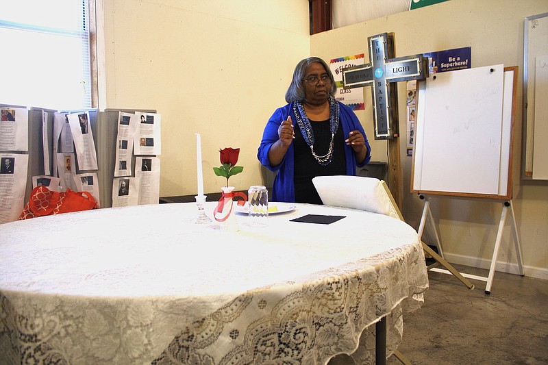 LeWanda Jackson demonstrates the different items on the "white table" which is traditionally in VFW halls. Each item on the table holds a symbolic meaning relating to soldiers who did and did not return from battle.