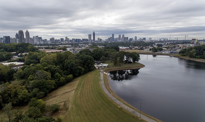 Reservoir No. 1, a 180 million-gallon water supply that has been out of service much of the past few decades, sits against the backdrop of the city skyline, Oct. 15, 2019, in Atlanta. The city made repairs and brought it back online in 2017, only to shut it down again after water leaks were noticed near businesses located beneath the dam. Were the dam to catastrophically fail, the water could inundate more than 1,000 single-family homes, dozens of businesses, a railroad and a portion of Interstate 75, according to an emergency action plan. (AP Photo/David Goldman)