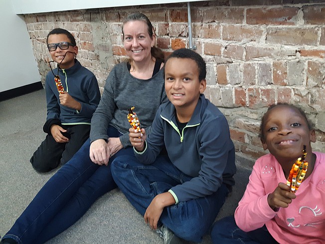 The Bolding family — Mikah, left, Rebekah, Tre and Mia Bolding — display their works from Saturday's Pony Bead Indian Corn craft event, the first of a series of events at the Discovery Place Interactive Museum with a Thanksgiving theme.