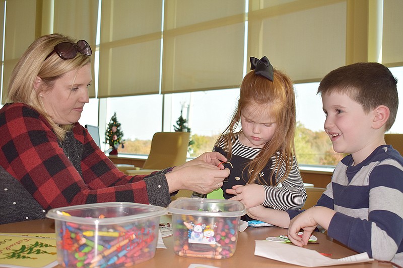 Leslie Dunlap, left, makes arts and crafts with daughter Lanie, 3, and son Liam, 6, at Sunday's second Festival of Trees at Goldschmidt Cancer Center. 