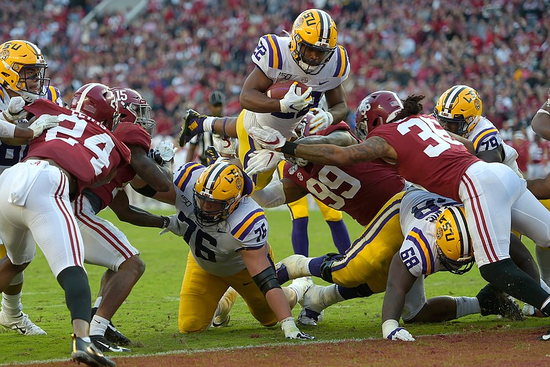 LSU running back Clyde Edwards-Helaire (22) dives over Alabama's Raekwon Davis (99) and Markail Benton (36) to score a touchdown in the first half of an NCAA college football game, Saturday, Nov. 9, 2019, in Tuscaloosa, Ala. (AP Photo/Vasha Hunt)
