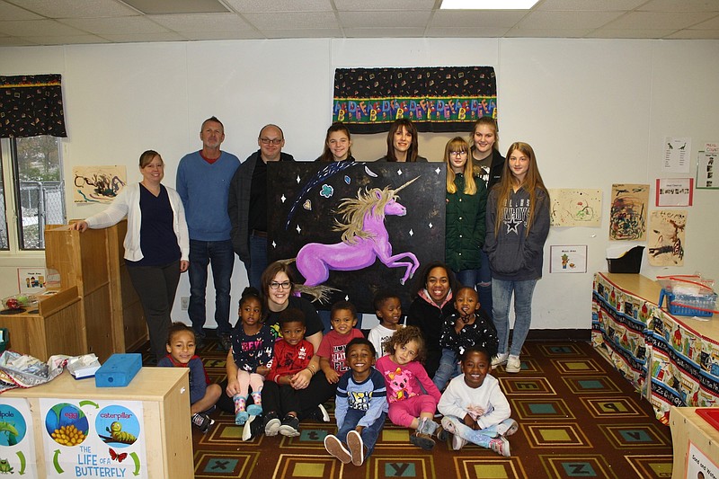 <p>Quinn Wilson/FULTON SUN</p><p>The Auxvasse Creative Arts Program and students from the Auxvasse Junior High Arts Club donated artwork to Head Start Preschool in Fulton on Monday morning. Pictured in the back row, from left are Teressa Huskey, Diamond Tripp, Jeremy Divers, Jenny O’Donley, DJ Wall, Rylee Milne and Bailey Hill.</p>