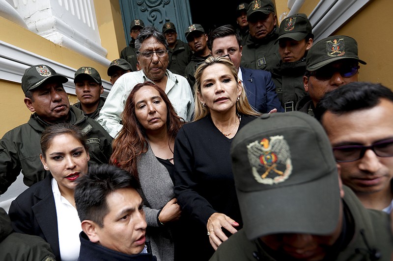 Senate second Vice President Yanine Anez, center right, arrives to Congress in La Paz, Bolivia, Monday, Nov. 11, 2019. Bolivian President Evo Morales' Nov. 10 resignation, under mounting pressure from the military and the public after his re-election victory triggered weeks of fraud allegations and deadly demonstrations, leaves a power vacuum and a country torn by protests against and for his government. (AP Photo/Natacha Pisarenko)