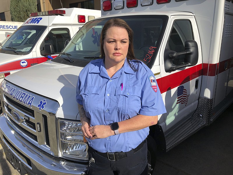 In this photo taken Nov. 6, 2019, Trisha Preston, a paramedic, poses outside the headquarters of her employer, American Medical Response, in Portland, Ore. Preston was attacked in the back of her ambulance by a patient in a mental health crisis earlier this year and sustained bruising, bite marks and a concussion that left her with temporary double vision and headaches. Paramedics in Portland are undergoing mandatory training in defensive tactics after a rash of high-profile attacks against them as they respond to 911 calls for people in a mental health or drug-related crisis. (AP Photo/Gillian Flaccus)