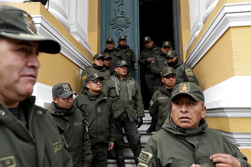 Police guard Congress in La Paz, Bolivia, Monday, Nov. 11, 2019. Bolivian President Evo Morales' Nov. 10 resignation, under mounting pressure from the military and the public after his re-election victory triggered weeks of fraud allegations and deadly demonstrations, leaves a power vacuum and a country torn by protests against and for his government. (AP Photo/Natacha Pisarenko)