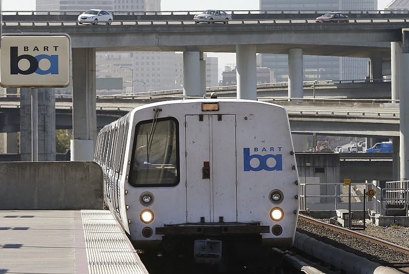 FILE - In this Oct. 15, 2013, file photo, a Bay Area Rapid Transit train departs the MacArthur station in Oakland, Calif. The head of the San Francisco Bay Area commuter train system is apologizing to a black rider who was detained and cited by police for eating a breakfast sandwich on a train platform, BART general manager Bob Powers said in a statement Monday, Nov. 11, 2019. (AP Photo/Ben Margot, File)