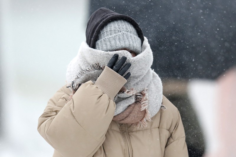 A woman walking the half mile from the Chicago Aquarium to the Adler Planetarium braces in a stiff wind and blowing snow off Lake Michigan, Monday, Nov. 11, 2019, in Chicago. (AP Photo/Charles Rex Arbogast)
