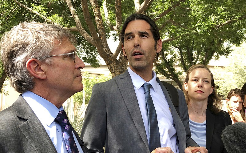 FILE - In this June 11, 2019, file photo, Scott Warren, center, speaks outside federal court, in Tucson, Ariz., after a mistrial was declared in the federal case against him. The second trial against Warren, a border activist accused of harboring immigrants in the country illegally, is set to start on Tuesday, Nov. 12, 2019. (AP Photo/Astrid Galvan, File)