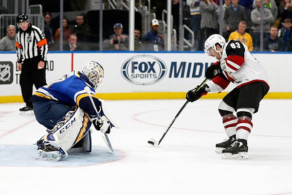 Conor Garland of the Coyotes scores the game-winning goal past Blues goaltender Jordan Binnington during a shootout Tuesday night in St. Louis.