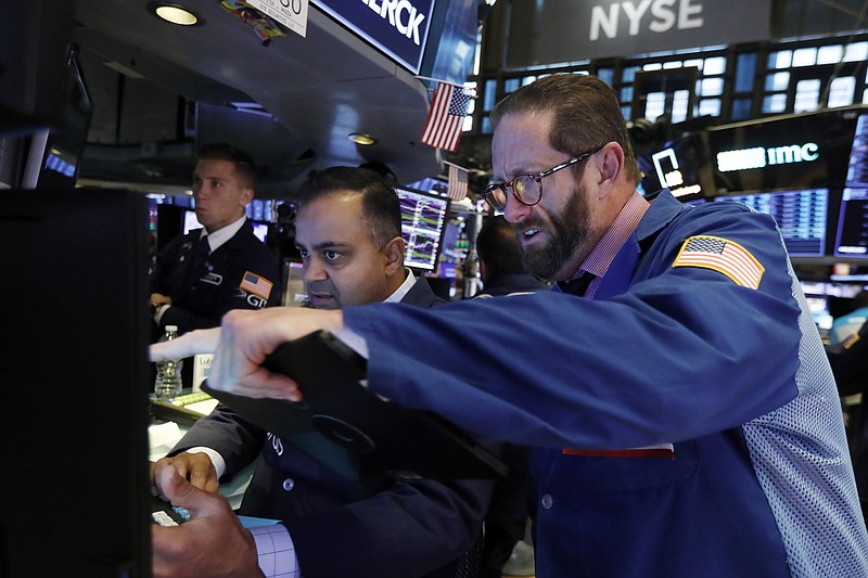 Trader Stephen Gilmartin, right, works with specialist Dilip Patel on the floor of the New York Stock Exchange, Wednesday, Nov. 13, 2019. Stocks are opening slightly lower on Wall Street led by declines in banks and industrial companies. (AP Photo/Richard Drew)