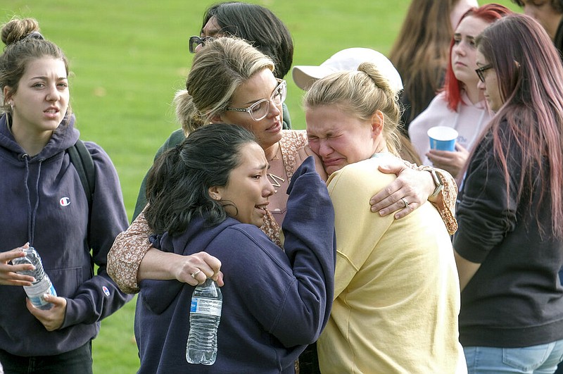 Students are comforted as they wait to be reunited with their parents following a shooting at Saugus High School that injured several people, Thursday, Nov. 14, 2019, in Santa Clarita, Calif. (AP Photo/Ringo H.W. Chiu)