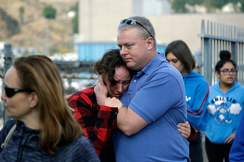 Students are escorted out of Saugus High School as some parents join them after reports of a shooting on Thursday, Nov. 14, 2019, in Santa Clarita, Calif. (AP Photo/Marcio Jose Sanchez)