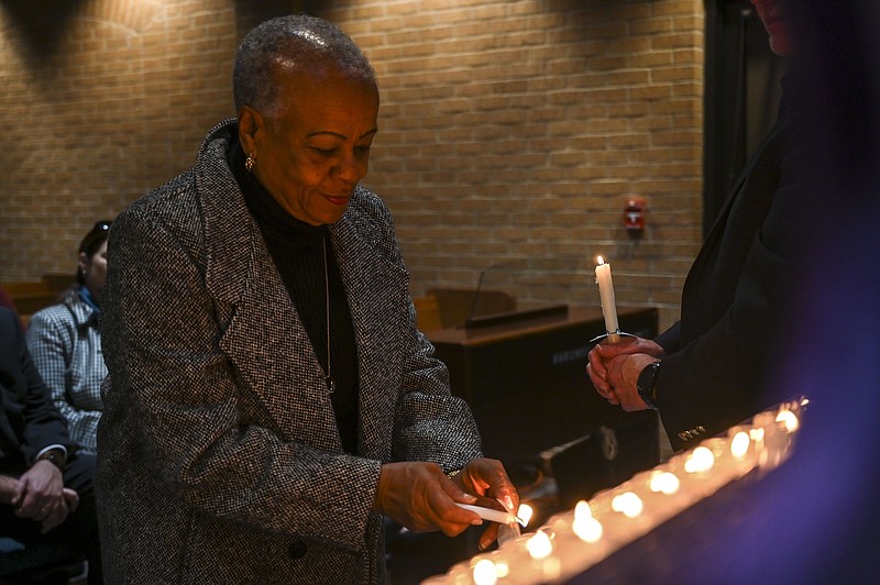Ida Brown lights a candle at the Alzheimer's Alliance Candlelight Service on Thursday at Willams Memorial United Methodist Church in Texarkana, Texas. The event at the chapel was officiated by pastor Brad Morgan and was held in the memory of friends and loved ones who have suffered from the disease. 