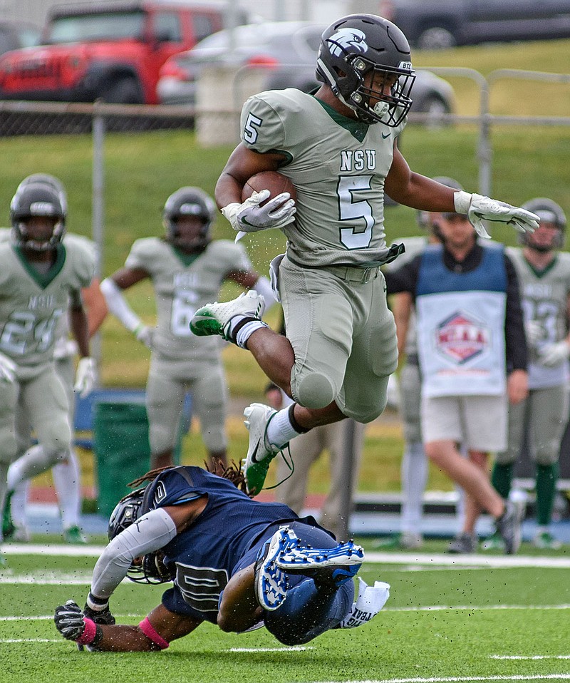 Northeastern State running back Kevin Jackson hurdles Lincoln safety Hasan Muhammad-Rogers as he tries to make a diving tackle during a game last month at Dwight T. Reed Stadium.