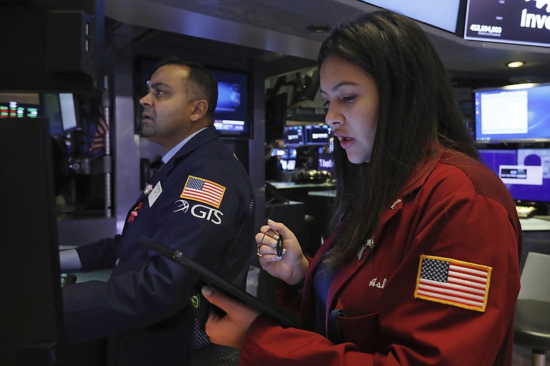 Specialist Dilip Patel, left, and trader Ashley Lara work on the floor of the New York Stock Exchange, Friday, Nov. 15, 2019. Stocks are opening broadly higher on Wall Street as hopes continued to grow that the U.S. and China were moving closer to a deal on trade. (AP Photo/Richard Drew)