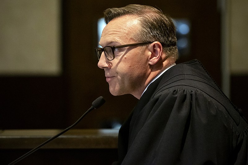 FILE - In this Aug. 26, 2019 file photo, Judge Thad Balkman reads a summary of his decision in the opioid trial at the Cleveland County Courthouse in Norman, Okla. Judge Balkman reduces amount Johnson & Johnson must pay state to help clean up opioid crisis by $107 million to $465 million on Friday Nov. 15, 2019. (Chris Landsberger/The Oklahoman via AP, Pool)