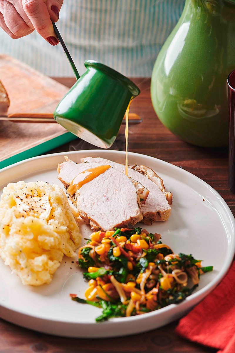 In this May 2019 photo gravy is poured on a plate of turkey, mashed potatoes and gravy and a side of sauteed broccoli rabe, corn and onions with crispy bacon, on a table in New York. If you remember that the turkey breast will take less time to cook than the legs, and that you can get a head start on your gravy, Thanksgiving will be a whole lot less stressful. (Cheyenne Cohen/Katie Workman via AP)