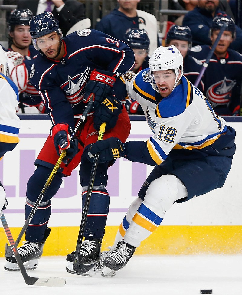 Seth Jones of the Blue Jackets passes the puck in front of Zach Sanford of the Blues during the second period of Friday night's game in Columbus, Ohio.