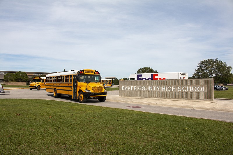 In this Oct. 17, 2019 photo, buses depart from Baker County High School in Glen St. Mary, Fla. Unease spread across Baker County when authorities arrested a 15-year-old who they say planned a massacre at the county's only high school. Anger grew when a judge dismissed second-degree felony charges against the boy.(AP Photo/Bobby Caina Calvan)