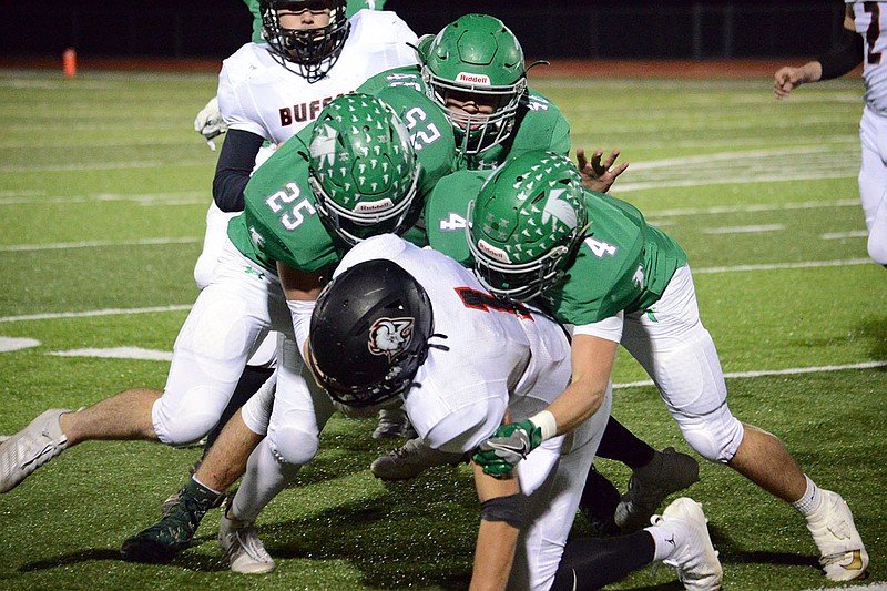 Blair Oaks defenders Levi Haney, Kyler Griep and Jayden Purdy tackle Jamen Smith of Buffalo during Friday night's Class 3 District 5 championship game at the Falcon Athletic Complex in Wardsville.