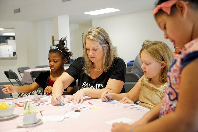 From left, Lexi, 7, Mindy and Kate Roling, 9, and Jaydeen Echols, 6, focus on coloring their princess crowns Saturday during Queens and Their Princesses High Tea at Living Hope Church in Jefferson City. Attendees were invited to wear whatever made them feel most beautiful to the event, which benefited the Building Community bridges nonprofit.