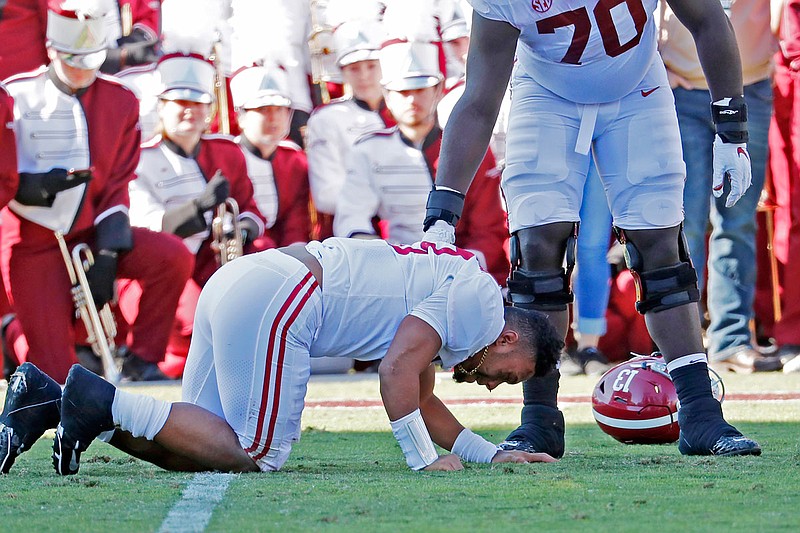 Alabama offensive lineman Alex Leatherwood (70) checks on quarterback Tua Tagovailoa (13) after he was injured in the first half of Saturday's game against Mississippi State in Starkville, Miss.