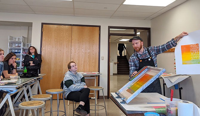 Tennessee artist Nick Satinover demonstrates his screen printing technique at William Woods University. He said he enjoys the freedom to experiment screen printing provides.