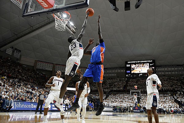 Connecticut's Akok Akok (23) blocks a shot by Florida's Gorjok Gak during the first half of Sunday's game in Storrs, Conn.