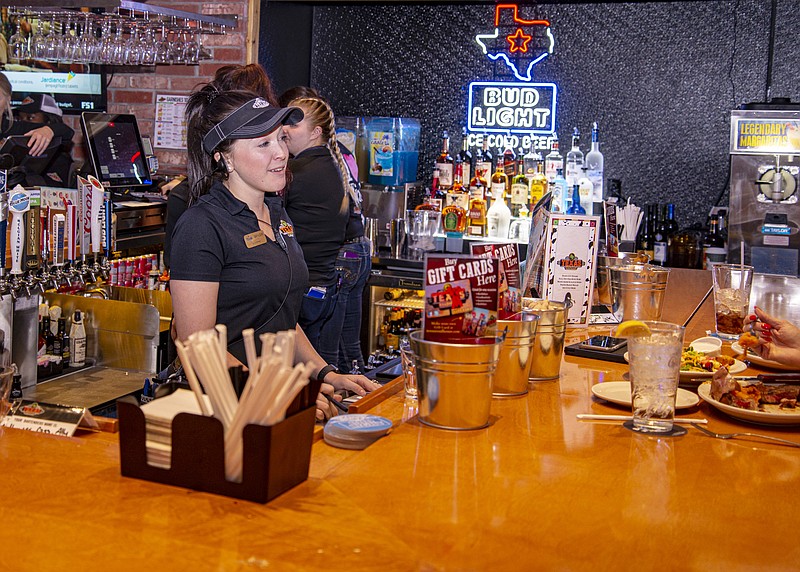 Texas Roadhouse Service Manager Skylar Ford talks with customers at the bar Friday during the restaurant's pre-opening event, which also served as a fundraiser for Special Olympics Missouri. Texas Roadhouse, at 3401 S. Ten Mile Road, will open officially Monday. Ken Barnes/News Tribune