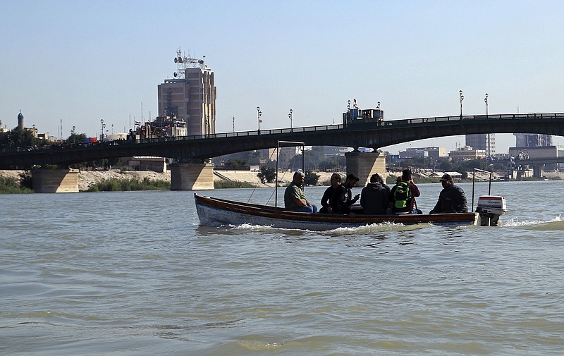 People cross the Tigris River in central Baghdad, Iraq, Tuesday, Nov. 19, 2019. Anti-government protests have effectively cut Iraq's capital in half and citizens are increasingly relying on boats to ferry them to the other side of the river city, as standoffs between demonstrators and security forces have shut three key bridges connecting east and west Baghdad. (AP Photo/Hadi Mizban)