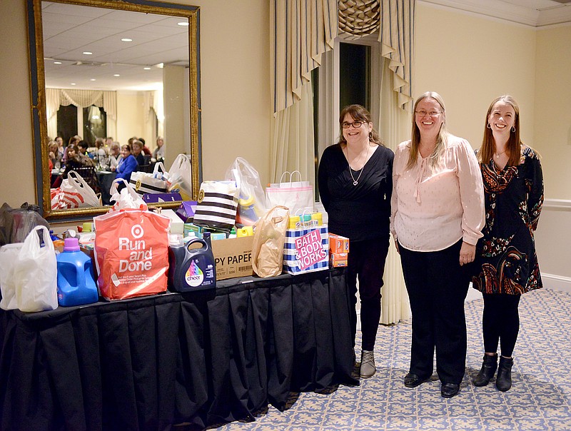 Chris Sooter and Anita Pinson, with the Rape and Abuse Crisis Services, and Zonta President Sarah Veile stand Tuesday next to items donated by members as part of Zonta's Centennial Challenge during the Zonta Centennial Celebration at the Jefferson City Country Club.