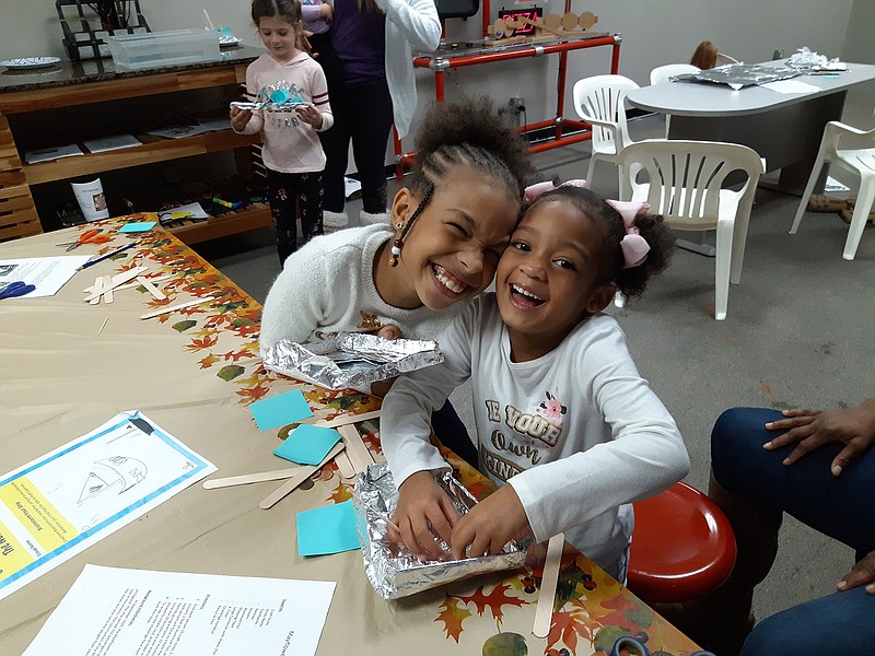 Arianna Thompson and Ava Jackson pose with their boats Saturday during Discovery Place's Mayflower Boat STEM Challenge, the third Saturday Thanksgiving-themed event for the month of November. Each participant designed and built a boat with the supplies given and then tested if it would float.