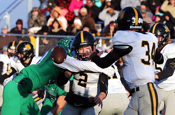 Cassville quarterback Deven Bates pitches the ball to running back Bowen Preddy as Blair Oaks linebacker Ian Nolph hits Bates during Saturday afternoon's Class 3 quarterfinal at the Falcon Athletic Complex in Wardsville.