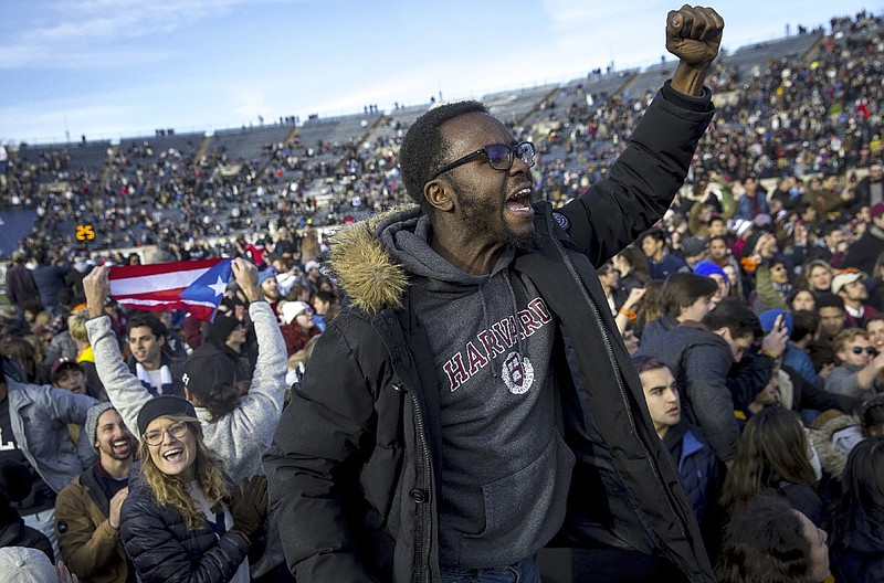 In this Saturday, Nov. 23, 2019, photo, Harvard and Yale students protest during halftime of the NCAA college football game between Harvard and Yale at the Yale Bowl in New Haven, Conn. Officials say 42 people were charged with disorderly conduct after the protest interrupted the game. (Nic Antaya/The Boston Globe via AP)