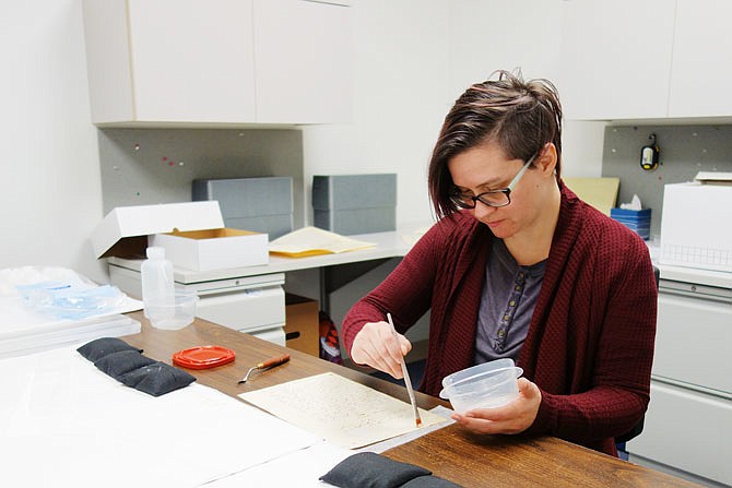 Lisa Janes, a field archivist with the Missouri State Archives, works to tease apart glue-adhered documents. She's spending time at the Kingdom of Callaway Historical Society's research center working with old circuit court case files.