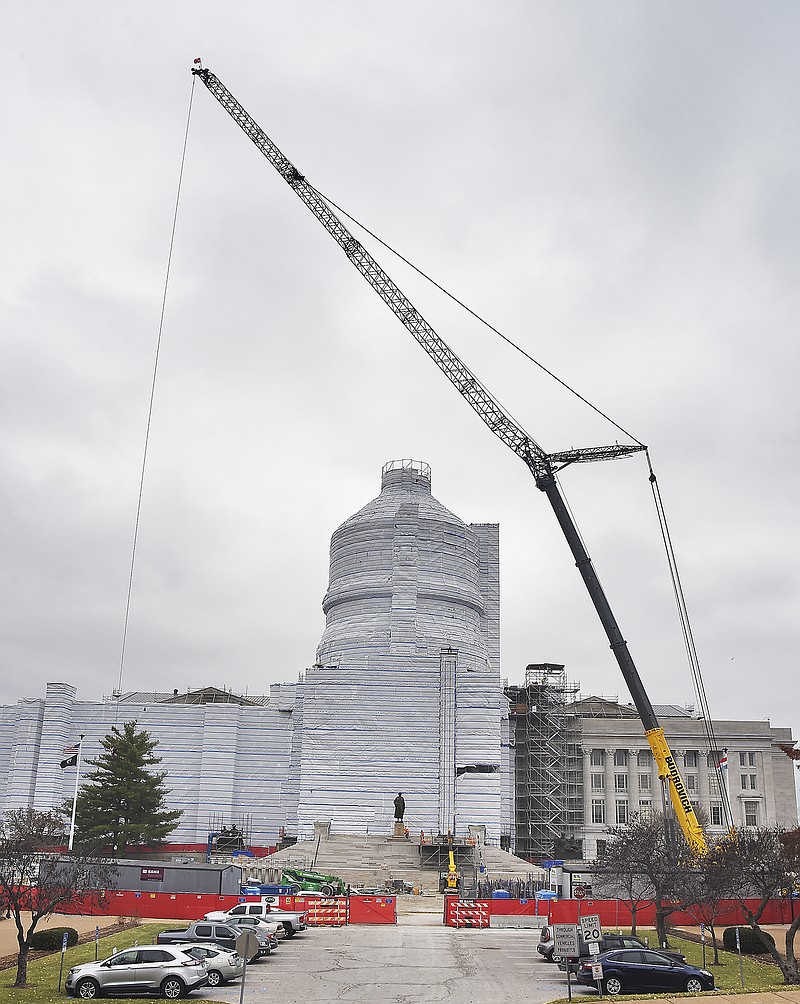 A crane looms large overhead as workers remove scaffolding from around the Thomas Jefferson statue on the Capitol's south steps. The crane will be on site to set the Ceres statue atop the Capitol in early December.