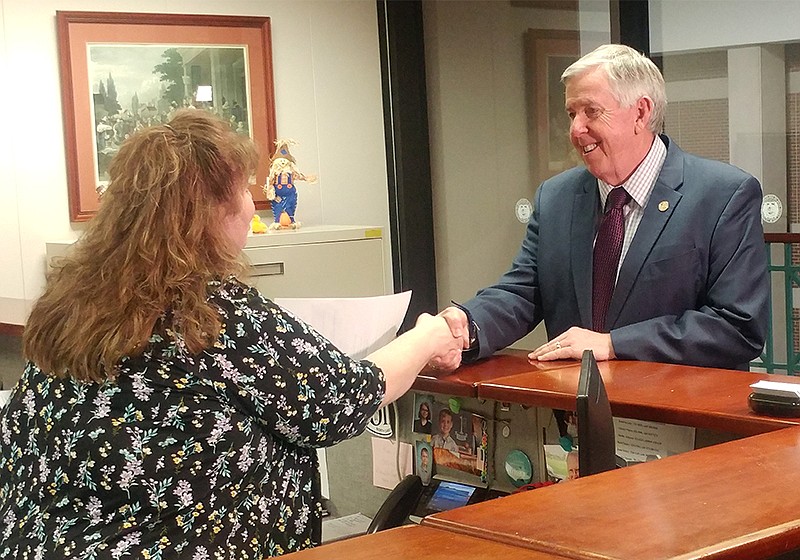 Dee Dee Straub, election support assistant with the Missouri Secretary of State's Office in Jefferson City, shakes hands with Gov. Mike Parson on Tuesday, Nov. 26, 2019, as Parson files the paperwork for President Donald Trump to appear on the March presidential primary ballot in Missouri.